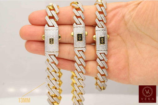 Close-up view of two hands displaying three different widths of 10K gold Monaco chain bracelets to compare size and pavé diamond coverage.