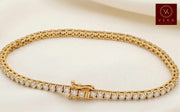 14K yellow gold tennis bracelet with 67 round natural diamonds in a secure 4-prong setting.
