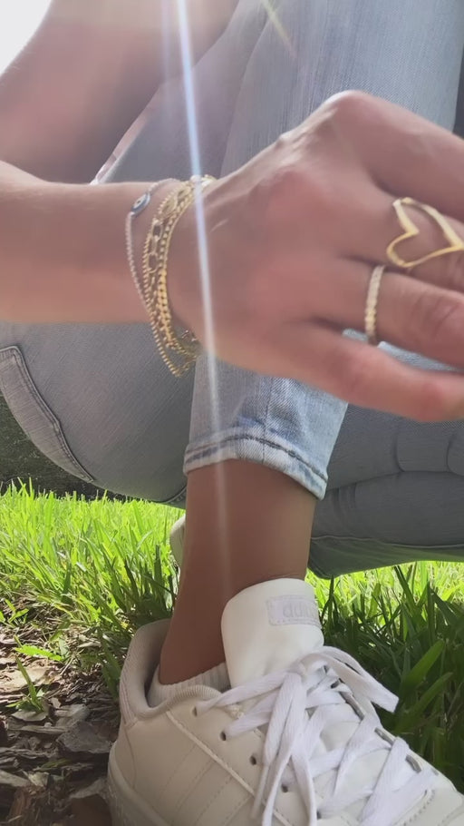 14K gold moon anklet bracelet with celestial charm showing lunar design on a video of a beautiful woman wearing it in a natural landscape.