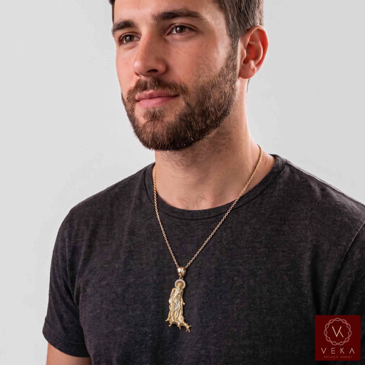 Male model wearing the 10K yellow gold San Lázaro pendant on a gold cuban link chain over a dark t-shirt - Veka Jewelry