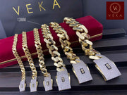 A collection of genuine 14k gold Monaco chain bracelets with Pavé Lock in various sizes displayed on a luxury red velvet box by Veka Jewelry