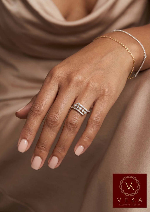Close-up of VEKA Jewelry's 10K yellow gold triple-row diamond band, featuring 1/3 ctw of natural SI diamonds, being worn on the index finger of a model's hand with nude nail polish