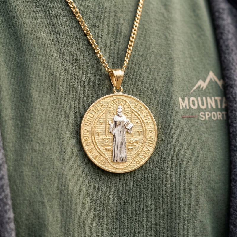 Close-up view of the two-tone gold Saint Benedict medallion paired with a gold cuban link chain on chest.