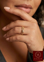 Close-up of a Latina model wearing a 14k solid gold XOXO eternity band ring by VEKA Jewelry.