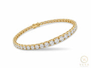 14K yellow gold graduated tennis bracelet with round clear cubic zirconia stones scaling from 2.5mm to 5mm on a clean white background - Veka Jewelry Orlando.