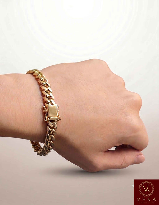 Man wearing a VEKA Jewelry 7mm 10K solid yellow gold Miami Cuban link bracelet on his wrist against a soft white beige background