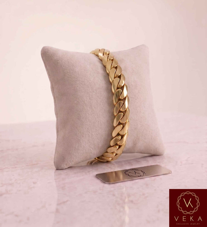 VEKA Jewelry 10mm Miami Cuban link bracelet in authentic 14K solid yellow gold displayed vertically on a beige velvet jewelry pillow