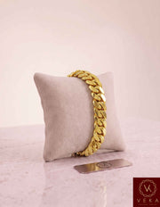 VEKA Jewelry 11mm Miami Cuban link bracelet in authentic 14K solid yellow gold displayed vertically on a beige velvet jewelry pillow