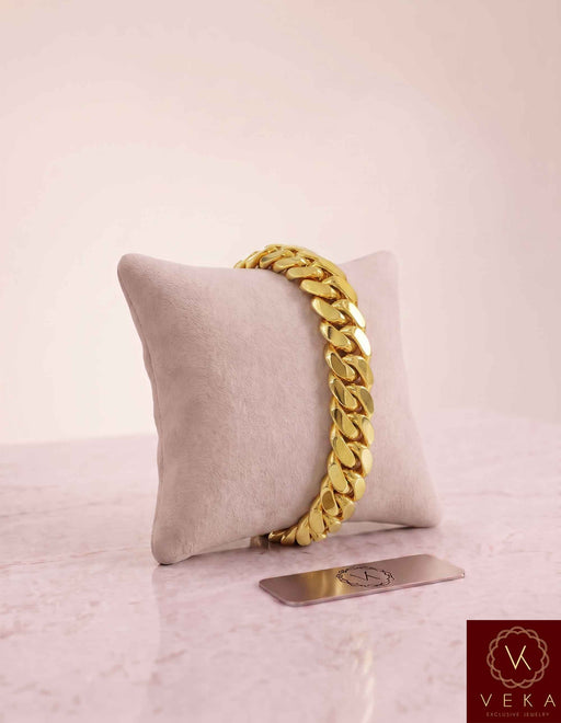 VEKA Jewelry 11mm Miami Cuban link bracelet in authentic 14K solid yellow gold displayed vertically on a beige velvet jewelry pillow