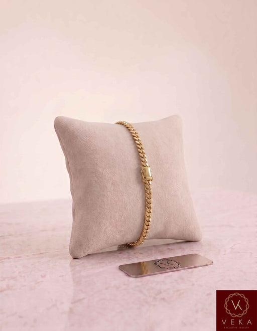 VEKA Jewelry 5mm Miami Cuban link bracelet in authentic 14K solid yellow gold displayed vertically on a beige velvet jewelry pillow.