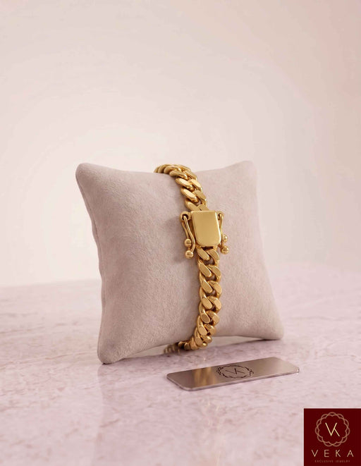 VEKA Jewelry 8mm Miami Cuban link bracelet in authentic 14K solid yellow gold displayed vertically on a beige velvet jewelry pillow