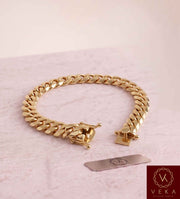 VEKA Jewelry 10mm Miami Cuban link bracelet in authentic 14K solid yellow gold displayed on a  luxurious marble stone with the Veka Jewelry Tag logo.