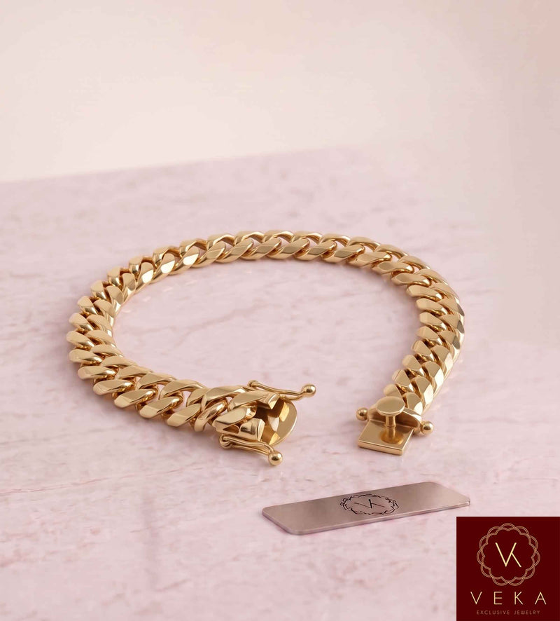 VEKA Jewelry 10mm Miami Cuban link bracelet in authentic 14K solid yellow gold displayed on a  luxurious marble stone with the Veka Jewelry Tag logo.