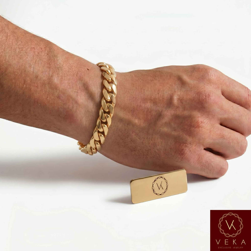 Man wearing a VEKA Jewelry 10mm 14K solid yellow gold Miami Cuban link bracelet on his wrist against a soft white beige background.