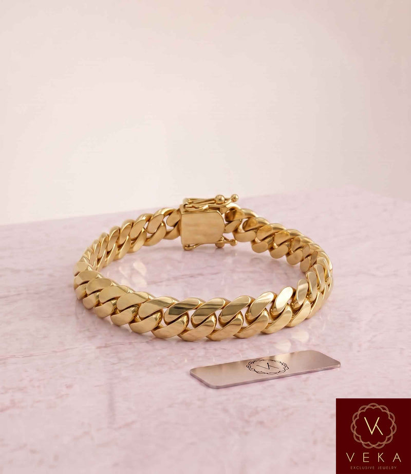 VEKA Jewelry 10mm Miami Cuban link bracelet in authentic 14K solid yellow gold displayed on a  luxurious marble stone with the Veka Jewelry Tag logo.