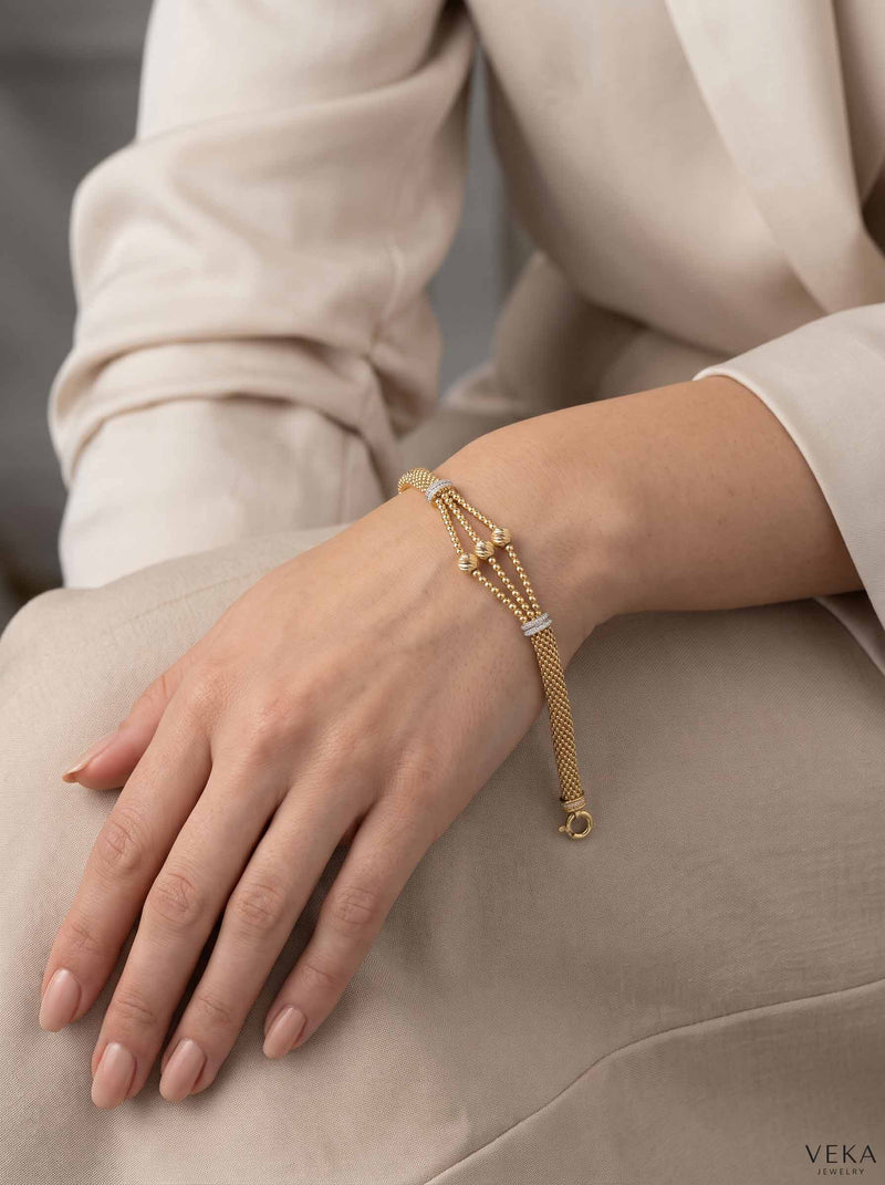 Close-up lifestyle view of a woman wearing the 14K yellow gold popcorn bead bracelet with luxury spring lock by Veka Jewelry