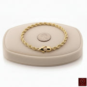 6mm genuine 14k yellow gold rope chain bracelet (21 grams, 8.5 inches) displayed on a beige stand by Veka Jewelry.