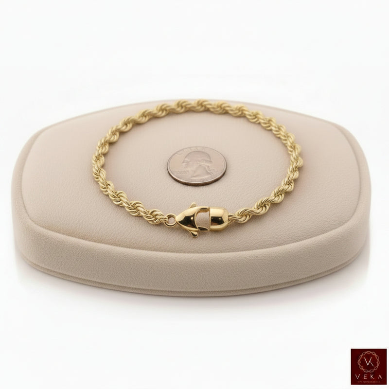 6mm genuine 14k yellow gold rope chain bracelet (21 grams, 8.5 inches) displayed on a beige stand by Veka Jewelry.