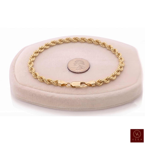 6mm genuine 14k yellow gold rope chain bracelet (21 grams, 8.5 inches) displayed on a beige stand by Veka Jewelry.