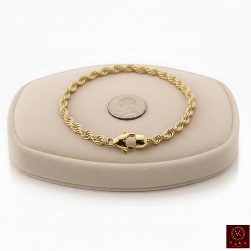 6mm genuine 14k yellow gold rope chain bracelet (21 grams, 8.5 inches) displayed on a beige stand by Veka Jewelry.