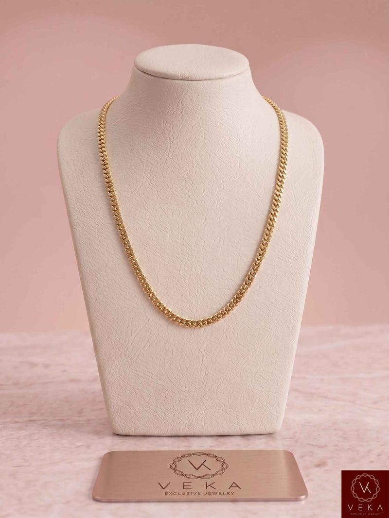5mm Solid Miami Cuban Link Chain in authentic 14K yellow gold displayed on a premium beige neck bust with a Veka Jewelry metal logo plate.