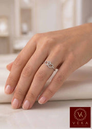Close-up of a woman wearing the VEKA Jewelry interlocking double heart diamond ring in 14k white gold on her ring finger.