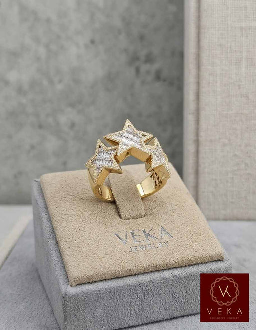 Professional studio shot of a VEKA Jewelry men's statement ring featuring three stars set with natural diamonds on a luxury beige display holder.