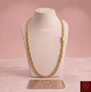 10K solid yellow gold 7mm Miami Cuban link chain, 24-inch necklace displayed on a beige luxury bust stand by Veka Jewelry.