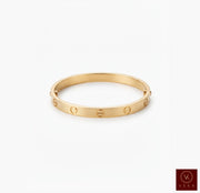Luxury yellow gold screw bangle bracelet displayed on a clean white studio background by Veka Jewelry