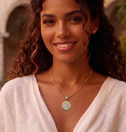 Unisex two-tone yellow and white gold Saint Michael religious medal pendant styled on a woman with Cuban chain.