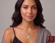 Women's solid yellow gold Santa Barbara diamond cut pendant necklace with ruby red accent stone worn on a female model