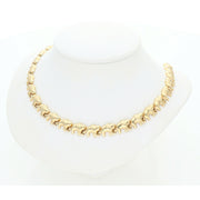 Top-down view of a high-polish 10K gold elephant link necklace on a minimalist white jewelry stand.