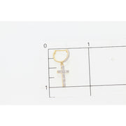Close up  of one 10 karat gold diamond cross huggie hoop earring  on top a square inch grid to have a glimpse of the actual size