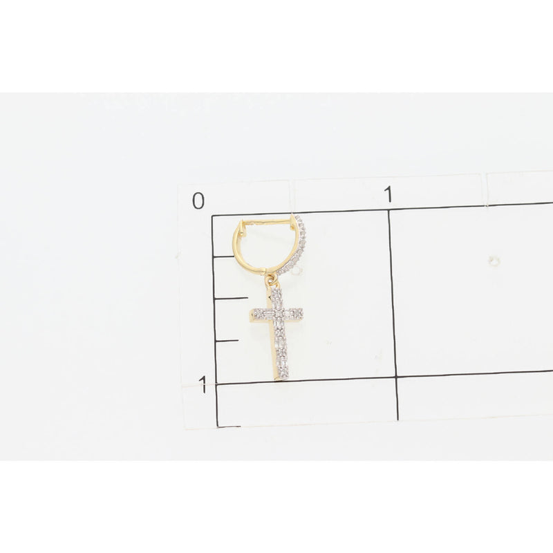 Close up  of one 10 karat gold diamond cross huggie hoop earring  on top a square inch grid to have a glimpse of the actual size