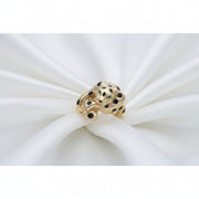 Close-up detail of a 14k gold feline leopard ring resting on soft white pleated silk fabric, highlighting the gold craftsmanship and enamel work.