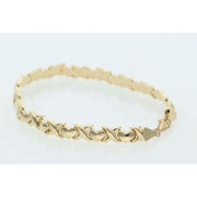 Close-up of a 6.1g 14K yellow gold stampato bracelet featuring alternating X and Heart links on a white background.