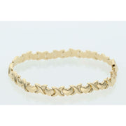 Close-up of a 6.1g 14K yellow gold stampato bracelet featuring alternating X and Heart links on a white background.