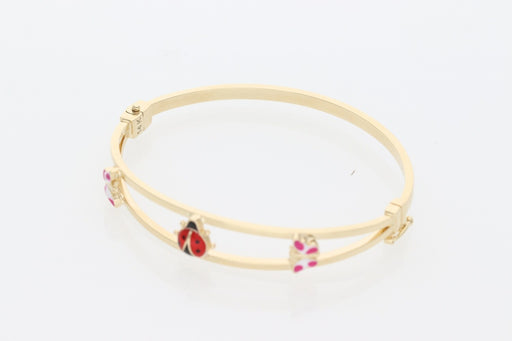 A 14K Real Gold bangle with ladybug charm  and two butterfly small charms on a white background 