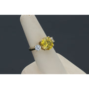 Yellow gold citrine ring with diamond-like zircon side stones - elegant three stone design in a ring display with dark gray background