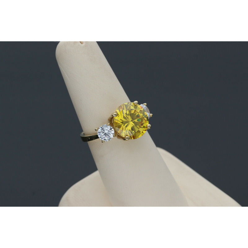 Yellow gold citrine ring with diamond-like zircon side stones - elegant three stone design in a ring display with dark gray background