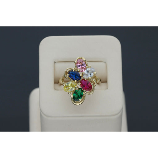 Graceful 14 karat Gold Multicolor Floral Ring 2025 Jewelry design with vibrant Sapphire accents, set on a beige ring holder in a gray backround.