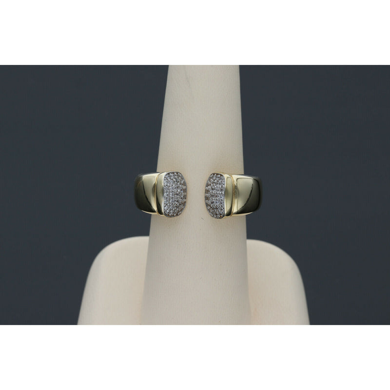 Elegant and  affordable 14 karat gold ring with opulent ends with stones encrustations, featuring a split band design, displayed on a beige ring stand against a dark background.