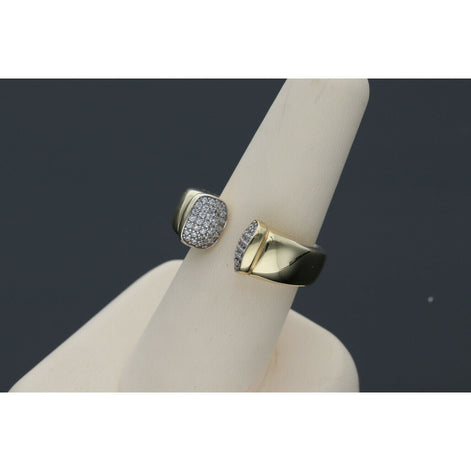 Elegant and  affordable 14 karat gold ring with opulent ends with stones encrustations, featuring a split band design, displayed on a beige ring stand against a dark background.