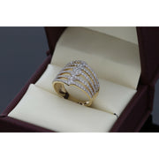 Side view of an elegant and simple 14 karat yellow gold that look like a cascade with lines of stones coming from the top. The ring is set on a leather box.