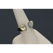 Elegant and  affordable 14 karat gold ring with opulent ends with stones encrustations, featuring a split band design, displayed on a beige ring stand against a dark background.