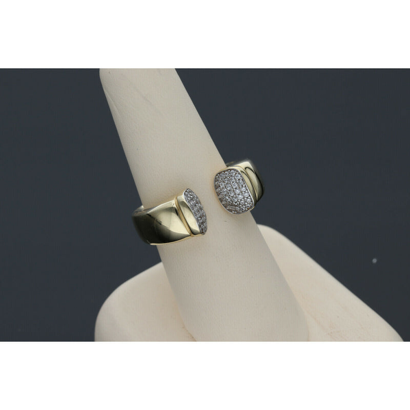 Elegant and  affordable 14 karat gold ring with opulent ends with stones encrustations, featuring a split band design, displayed on a beige ring stand against a dark background.