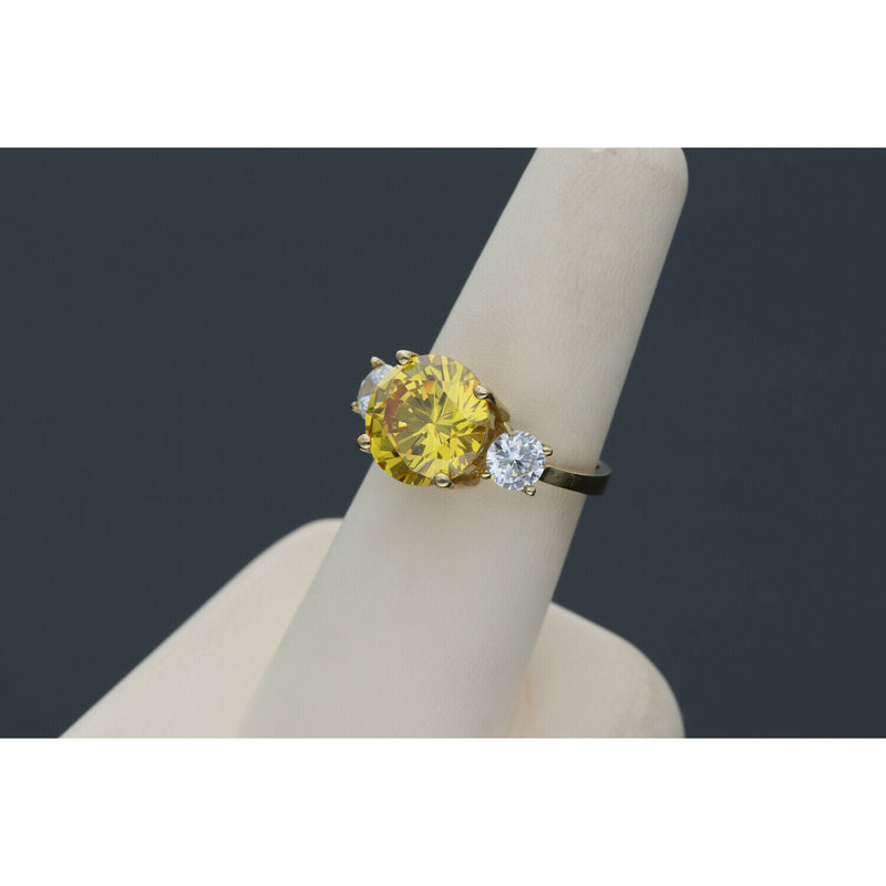 Yellow gold citrine ring with diamond-like zircon side stones - elegant three stone design in a ring display with dark gray background