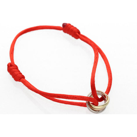 K gold three tone macrame bracelet with red cord showing adjustable sliding knots and tri-color gold rings