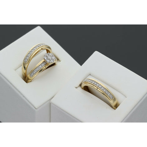 A 14 karat gold yellow gold wedding ring with a central flower diamond, presented in a white ring box along with another box in which there is the Men's wedding band in a channel style diamonds.