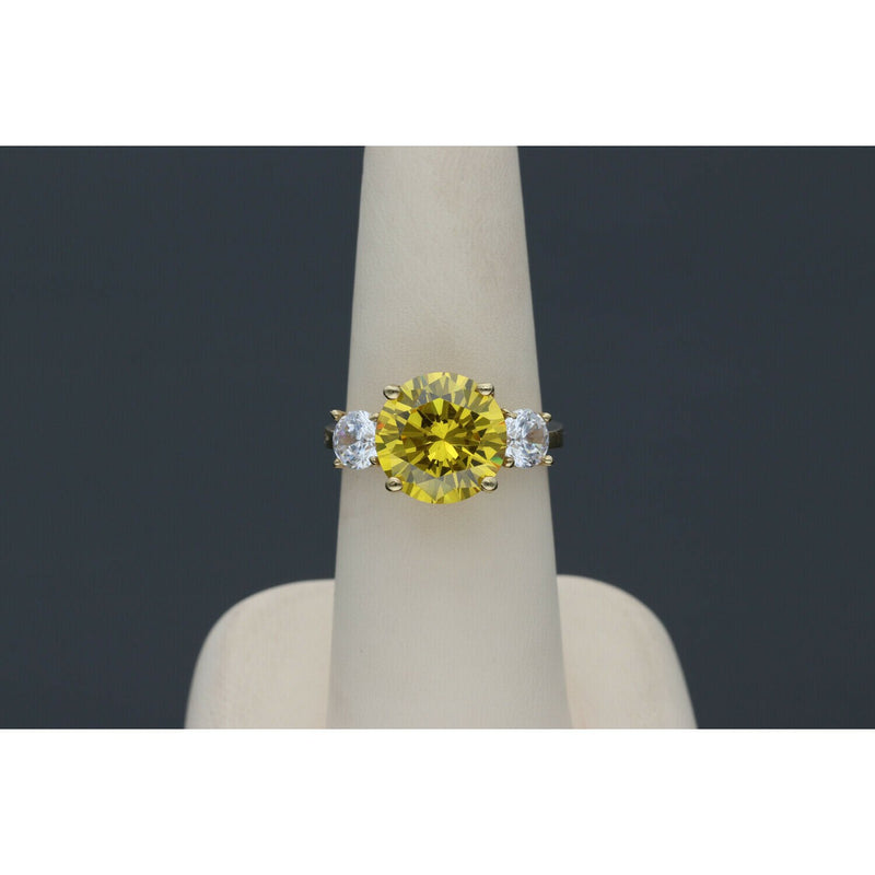 Yellow gold citrine ring with diamond-like zircon side stones - elegant three stone design in a ring display with dark gray blackground